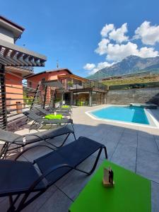eine Terrasse mit Stühlen und einem Pool in der Unterkunft The Lake Home in Colico