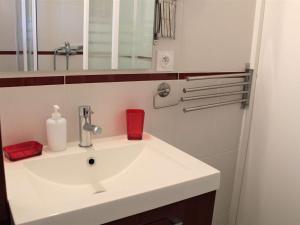La salle de bains est pourvue d'un lavabo blanc et d'un miroir. dans l'établissement Appartement Vars, 1 pièce, 2 personnes - FR-1-330B-130, à Vars