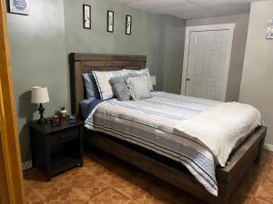 1 dormitorio con 1 cama y 1 mesa con lámpara en Perfect Getaway Spot in the Northeast Kingdom, en North Troy