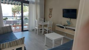 - un salon avec une télévision, une table et des chaises dans l'établissement APARTAMENTOS BUNGAMERICA n114, à Playa de las Americas