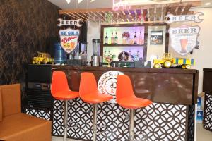 a bar with orange stools in a restaurant at THE HOTEL PARADISE in Gorakhpur