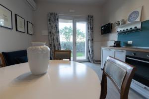 a white vase sitting on a table in a kitchen at Tenuta Tre Gemme a Mare - Suite Blu Vista mare in Pescara