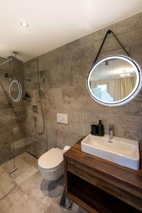 La salle de bains est pourvue d'un lavabo, de toilettes et d'un miroir. dans l'établissement Das Lindtal - Appartements, à Finkenberg