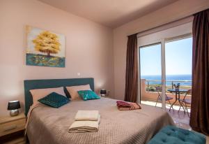 a bedroom with a bed with a view of the ocean at Kalypso Sea View Villa in Koskinou