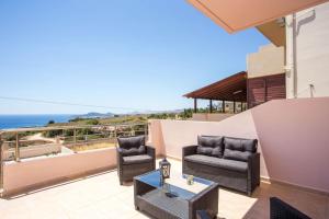 a patio with chairs and a table and the ocean at Kalypso Sea View Villa in Koskinou
