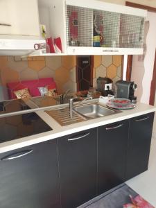 a kitchen with a sink and a counter at Le case di Grazia in Gaeta