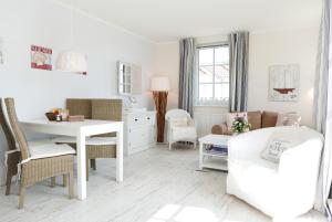 a white living room with a white table and chairs at Haus Meeresblick FeWo Strandperle in Baabe