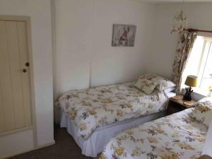 1 dormitorio con 2 camas y ventana en Fern Dale Cottage, en Stockland