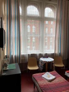 a room with a large window with chairs and a bed at U Szermierzy in Wrocław