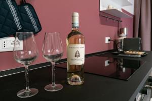 butelkę wina i dwa kieliszki wina na blacie w obiekcie Tenuta Tre Gemme a mare - Suite Purple w mieście Pescara