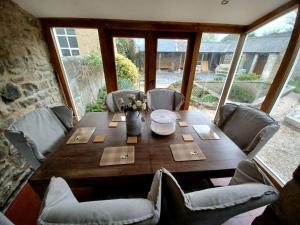 uma mesa de madeira com cadeiras e um vaso de flores em Unique Countryside Cottage close to Sunderland em Houghton le Spring