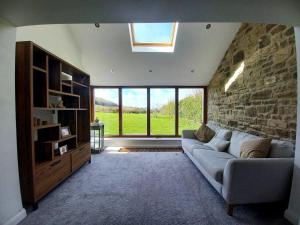 a living room with a couch and a stone wall at Unique Countryside Cottage close to Sunderland in Houghton le Spring