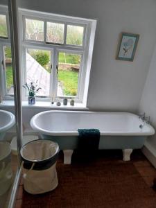 eine Badewanne im Bad mit Fenster in der Unterkunft Unique Countryside Cottage close to Sunderland in Houghton le Spring