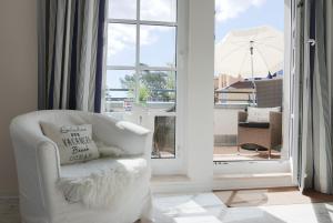 a white chair in a room with a window at Haus Meeresblick FeWo Strandperle in Baabe