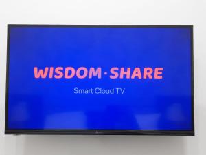 una pantalla de televisión con las palabras "compartir sabiduría" y "Smart Cloud tv" en TASHRIF HOTEL, en Qarshi