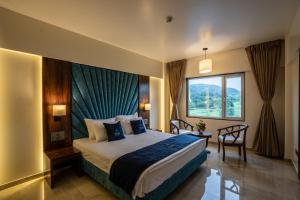 a hotel room with a bed and a window at Mastiff Grand The Sia Palace Suites & Banquets, Khopoli, Near Imagica in Khopoli