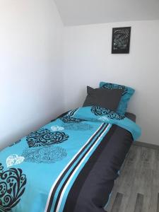 uma cama com um edredão azul e preto em Maisonnette cosy à Châtillon-Coligny em Châtillon-Coligny