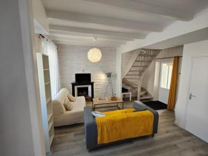 een woonkamer met een gele bank en een trap bij Charmante maison de Ville , 4 personnes , LES HERBIERS in Les Herbiers
