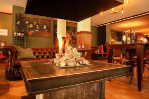 a bar with a fireplace in the middle of a room at Comfort Rooms by EuroParcs De Hooge Veluwe in Arnhem