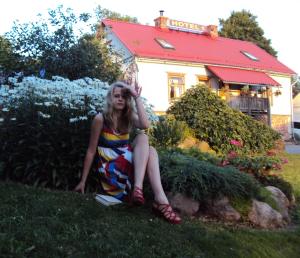 a woman in a colorful dress sitting in the grass at Saule in Talsi