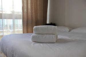 two towels are stacked on top of a white bed at C056-Cannes Rue Antibes - Studio in Cannes
