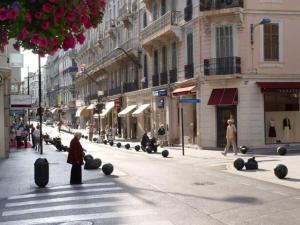 a woman standing in the middle of a street with luggage at C056-Cannes Rue Antibes - Studio in Cannes