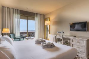 a hotel room with a bed and a desk and a television at The Lince Nordeste in Nordeste