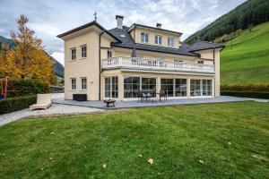 ein großes Haus mit großem Rasen davor in der Unterkunft Alpen Living - 1 Stock Ganz in Steinhaus