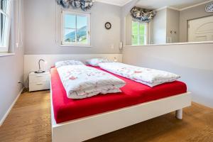 a bedroom with a bed with a red blanket at Alpen Living - 1 Stock Ganz in Cadipietra
