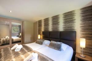 ein Schlafzimmer mit einem großen Bett und einem großen Spiegel in der Unterkunft Appartement Chesery in Chamonix-Mont-Blanc