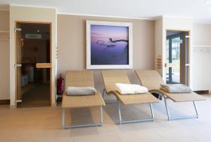 ein Esszimmer mit Stühlen und einem Gemälde an der Wand in der Unterkunft Haus Meeresblick - Ferienwohnung Suedost A 4.05 (Ref. 128720) in Baabe