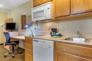 eine kleine Küche mit einer Spüle und einer Mikrowelle in der Unterkunft Suburban Studios South Bend in South Bend