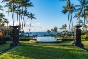 a pool at the resort with palm trees and the ocean at Hana-Maui Resort, a Destination by Hyatt Residence in Hana