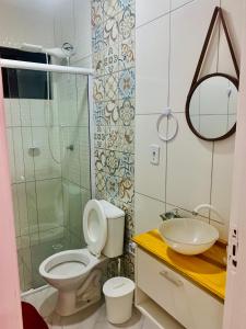 a bathroom with a toilet and a sink and a shower at Pousada cantinho do Descanso in Penha
