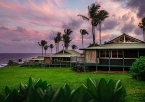 a house with palm trees in front of the ocean at Hana-Maui Resort, a Destination by Hyatt Residence in Hana
