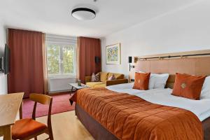 een hotelkamer met een groot bed met een oranje deken bij Landvetter Airport Hotel, Best Western Premier Collection in Landvetter