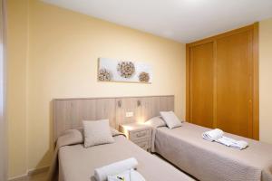 a room with two beds and a cabinet at La Perla D23 By Médano Rentals in El Médano +17 photos