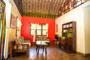 ein Wohnzimmer mit roten Wänden, einem Sofa und einem Tisch in der Unterkunft Oasis Diani Beach Villas in Diani Beach