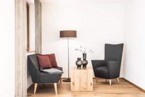 a living room with two chairs and a lamp at Huus123 in Au im Bregenzerwald