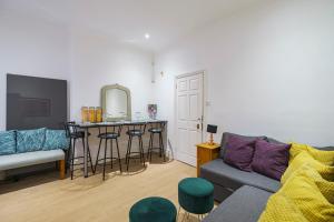 a living room with a couch and a bar at Larger Groups Apartment with Garden and Parking in London