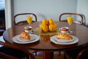 einem Holztisch mit zwei Teller Croissants und Orangen in der Unterkunft Art Deco Apartament dla 6 osób Chorzów/Katowice 6A in Chorzów