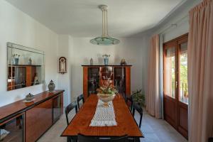 Dúplex con Terraza في خافيا: غرفة طعام مع طاولة وكراسي خشبية