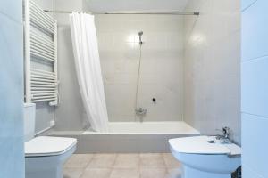 uma casa de banho com uma banheira, um WC e um lavatório. em Dúplex con Terraza em Xàbia