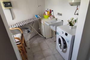 uma pequena cozinha com uma máquina de lavar roupa e um lavatório em Dúplex con Terraza em Xàbia