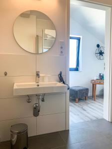 a bathroom with a sink and a mirror at PRIMA Inn Unterkunft direkt über der "Bar am Minimax" in Neuruppin