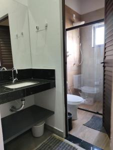 a bathroom with a sink and a toilet and a shower at Pousada Refúgio da Serra in Pirenópolis