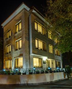 a large brick building with lit windows at night at Vila Paris Boutique Hotel in Bucharest