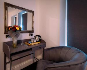 a living room with a chair and a mirror at The Friendship Hotel in Stocksbridge