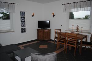 a living room with a tv and a table and chairs at Ferienwohnung Scholz in Lühmannsdorf