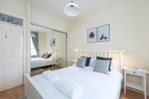 - une chambre avec un lit blanc et un salon dans l'établissement Bright and modern 2 bed apartment, à Édimbourg